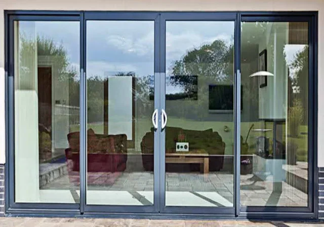 Four-panel aluminum sliding glass doors with dark frame and clear glazing