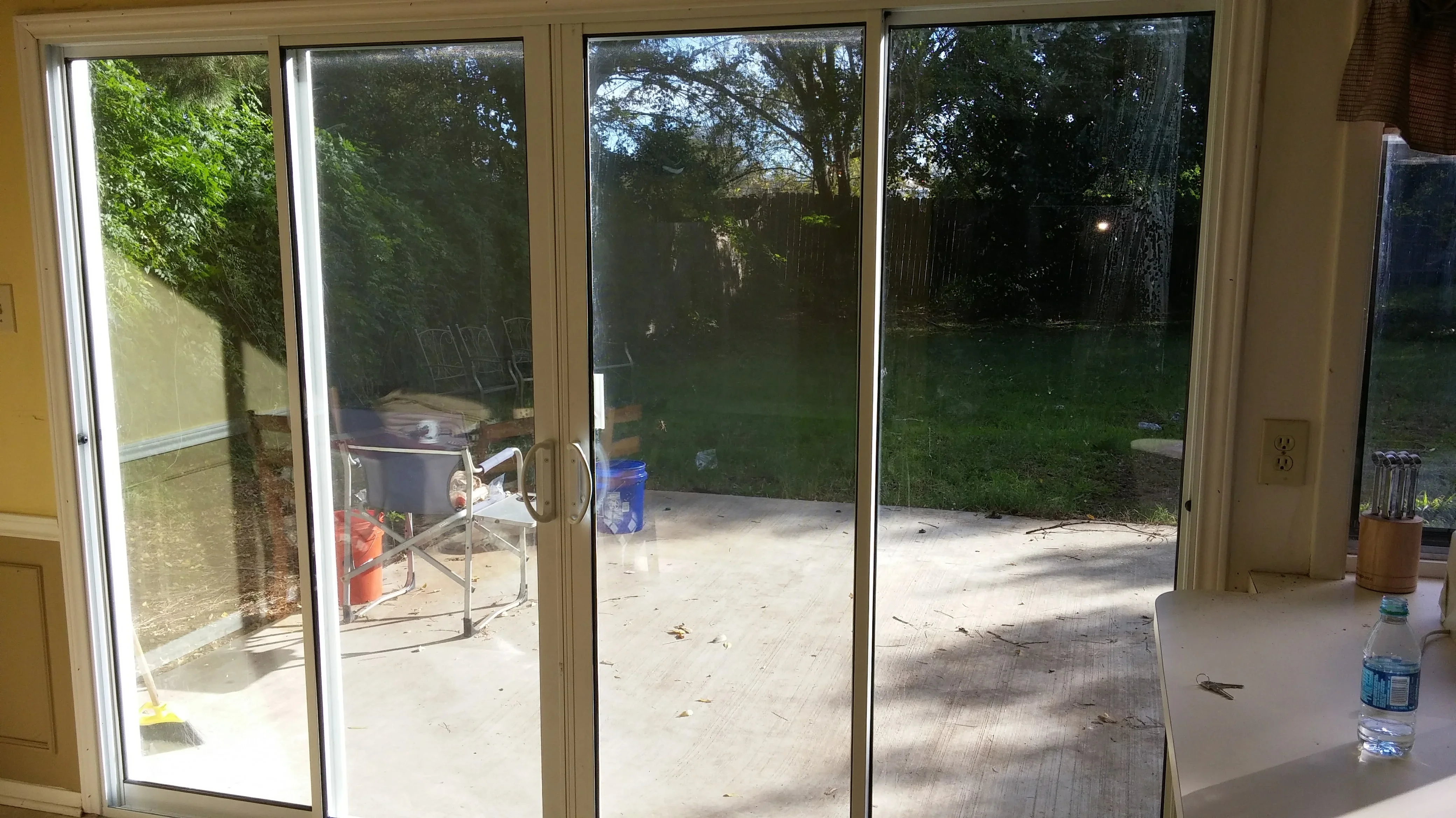 Four aluminum-framed sliding glass patio doors with clear glass panels opening to backyard patio