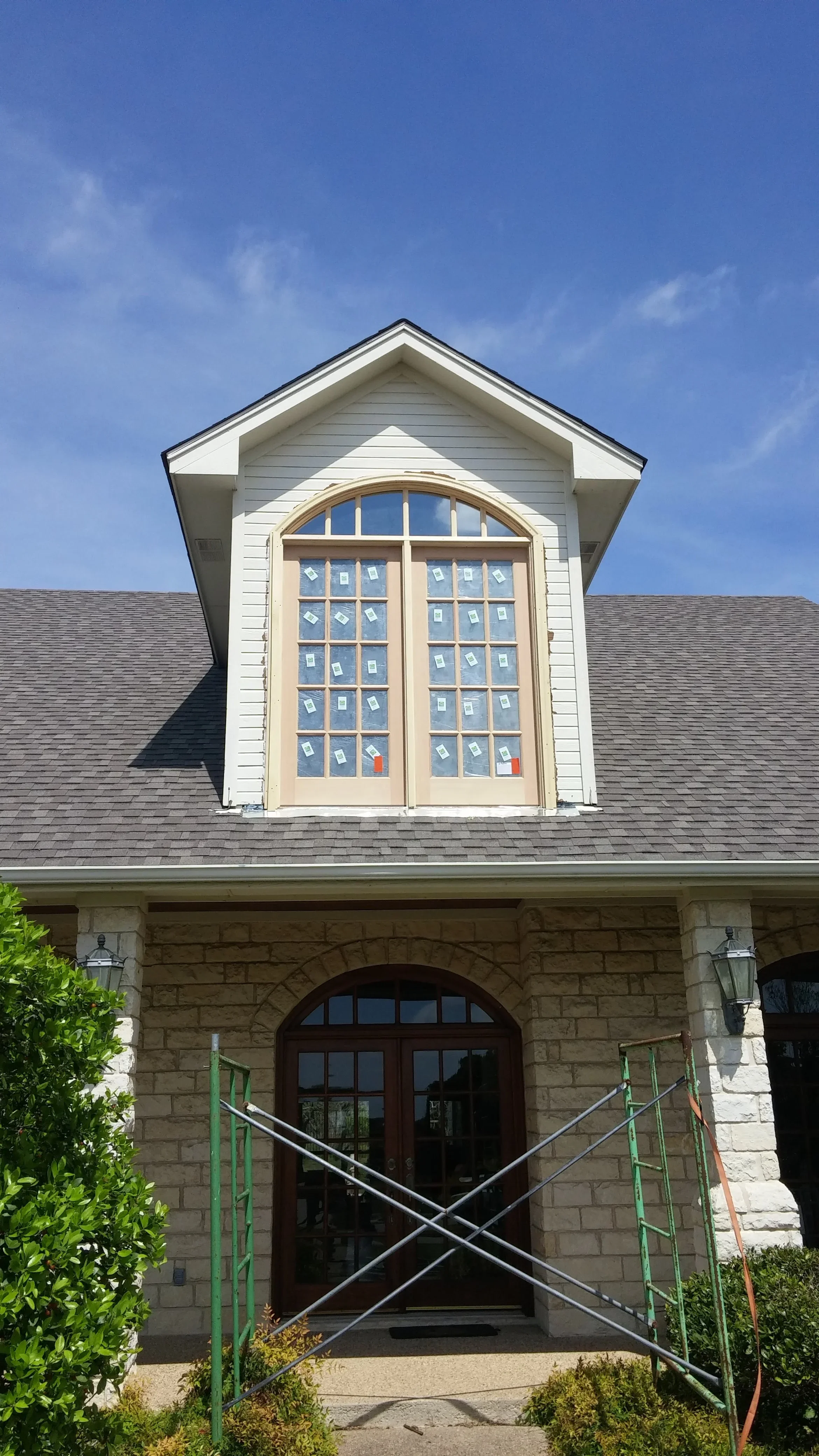 Custom arched double doors with transom window in cream finish, multi-pane blue glass design