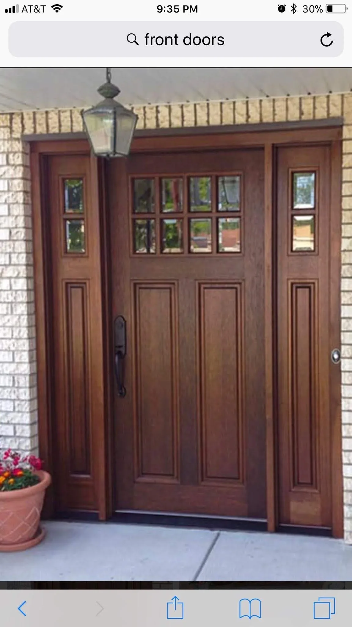 Mahogany wood entry door with six-light upper panels and sidelights on brick home