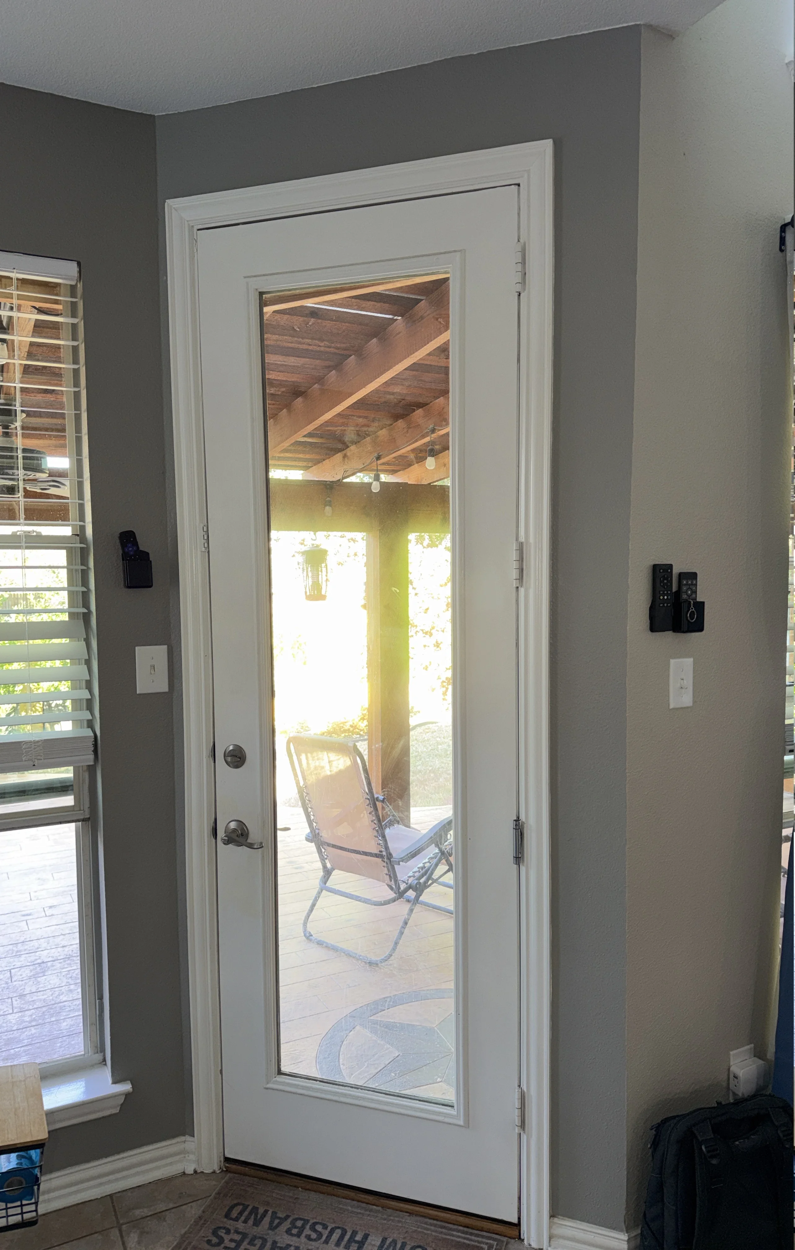 White French patio door with glass panel and dual locks installed in gray wall with white trim